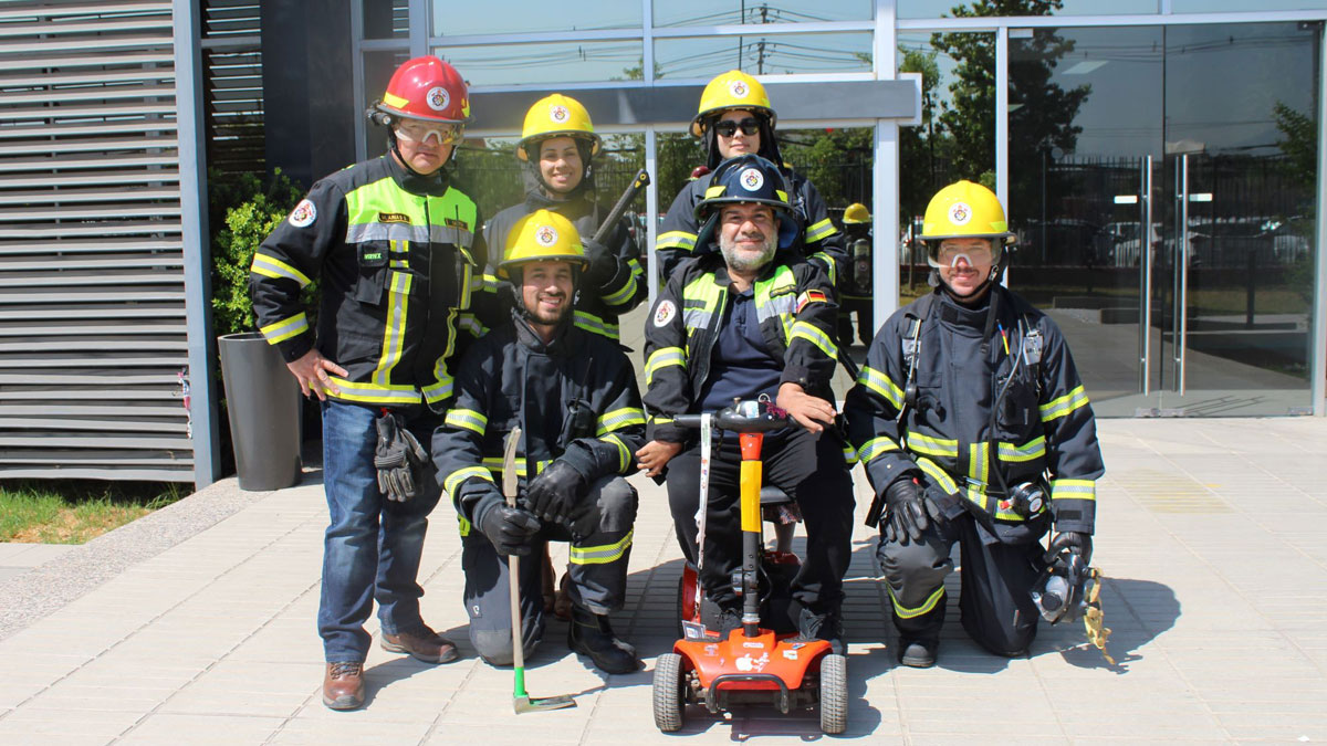 Rodrigo Caceres on his special wheelchair together with his colleagues from the Chile Emergency Brigade in front of the entrance of the Grünenthal Site in Santiago.