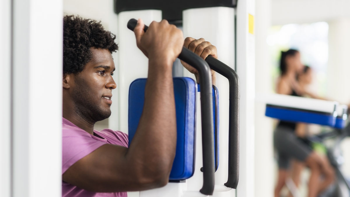 Young african american man training in fitness gym