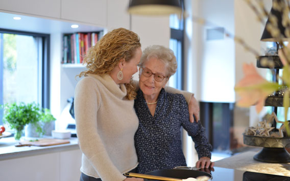 Middle-aged woman embracing her elderly mother