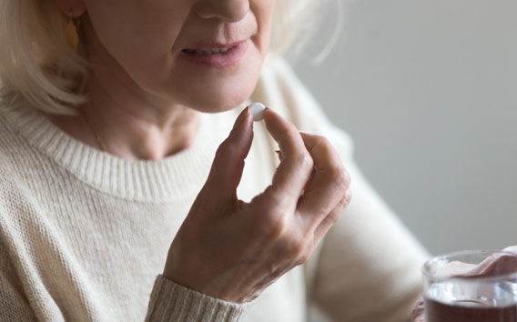Woman taking medicine with a glass of water