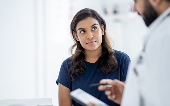 Young woman talking to doctor 