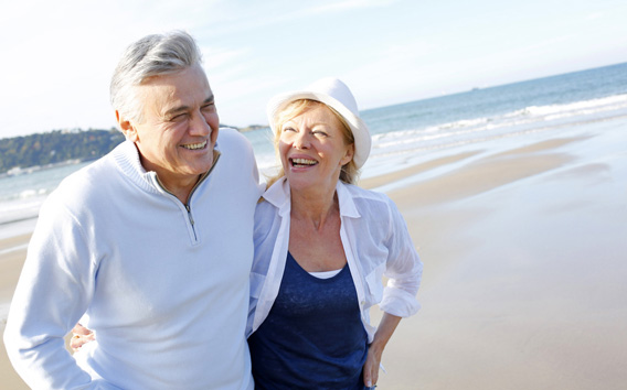 Senior couple walking on the beach in fall season